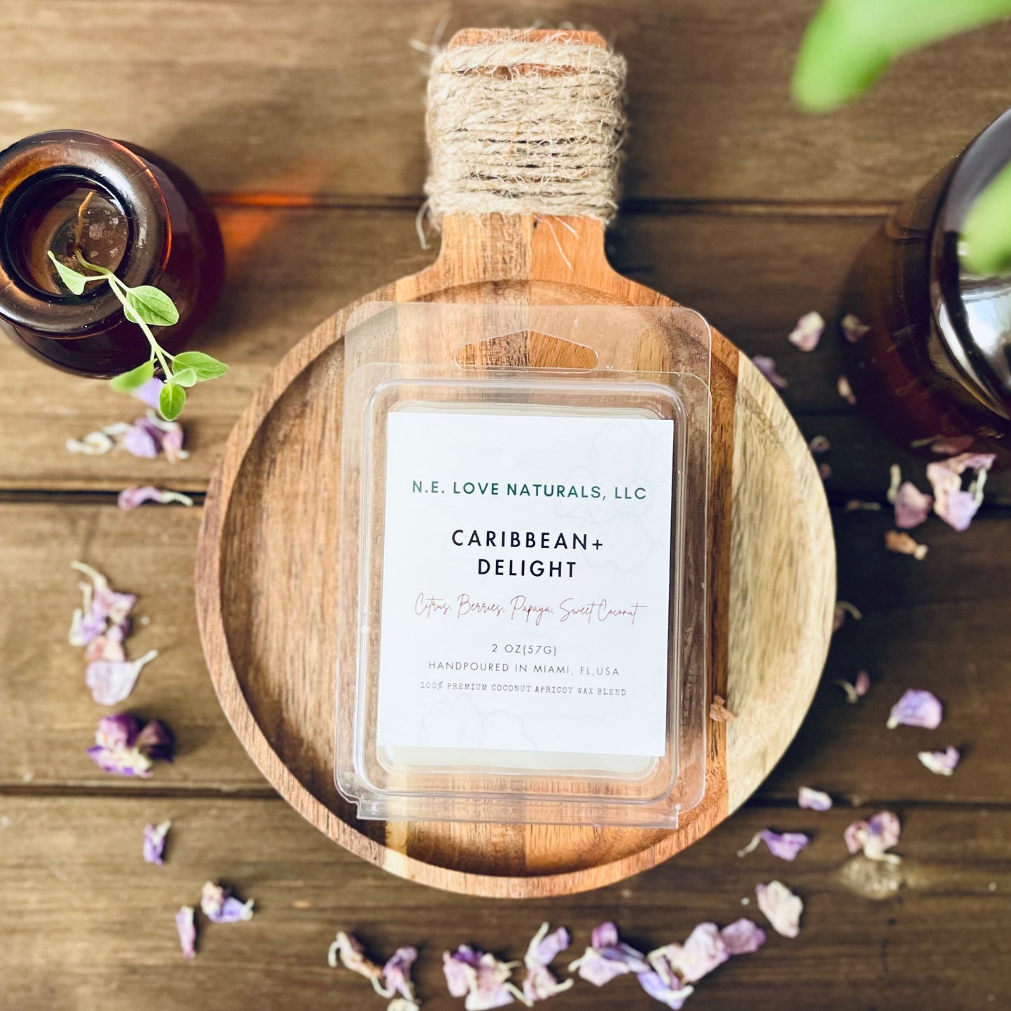 Wax Melt labeled 'Caribbean Delight' by N.E. Love Naturals on a wooden tray with decorative elements.